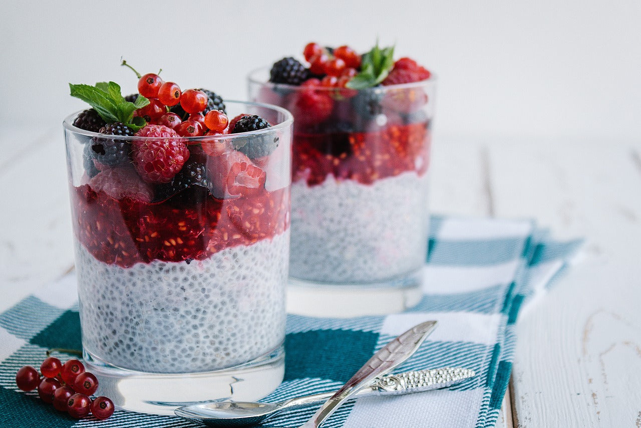 Chia Pudding mit Beeren in zwei Gläsern mit Beeren Deko