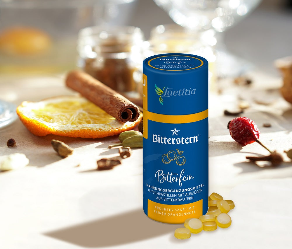 Laetitia Bitterfein Pastillen stehen auf Tisch mit Gewürzen, Orangenschale und Hagebutte im Hintergrund