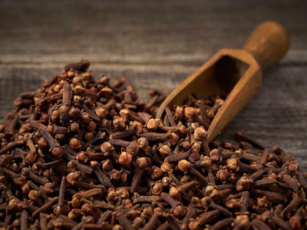 Gewürznelken auf einem Holztisch mit einer Schütte