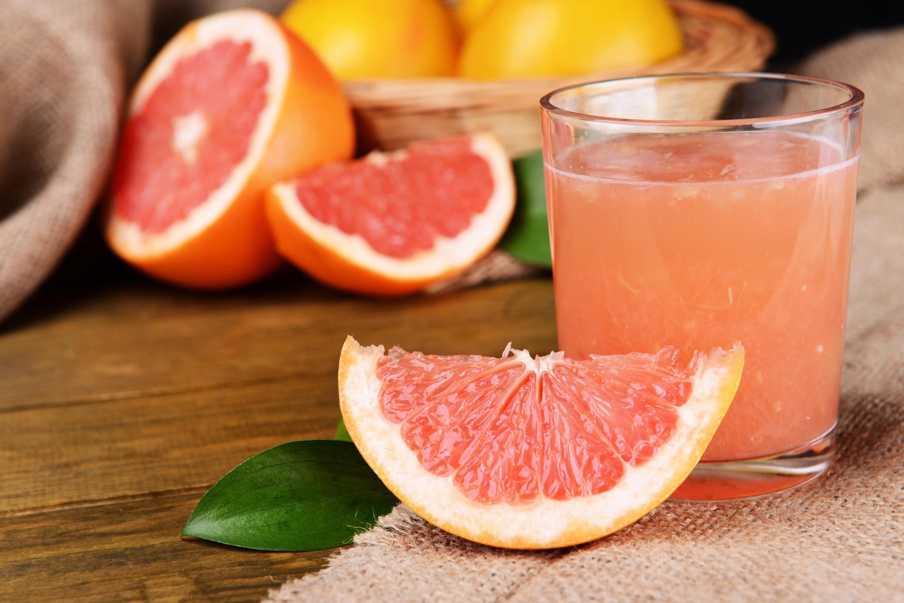 Frisch gepresster Grapefruitsaft mit aufgeschnittener rosa Grapefruit – fruchtige Bitterstoffe als natürlicher Vitalstofflieferant.