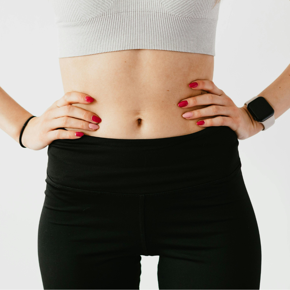 Trainierter Bauch und Hände in der Hüfte gestemmt