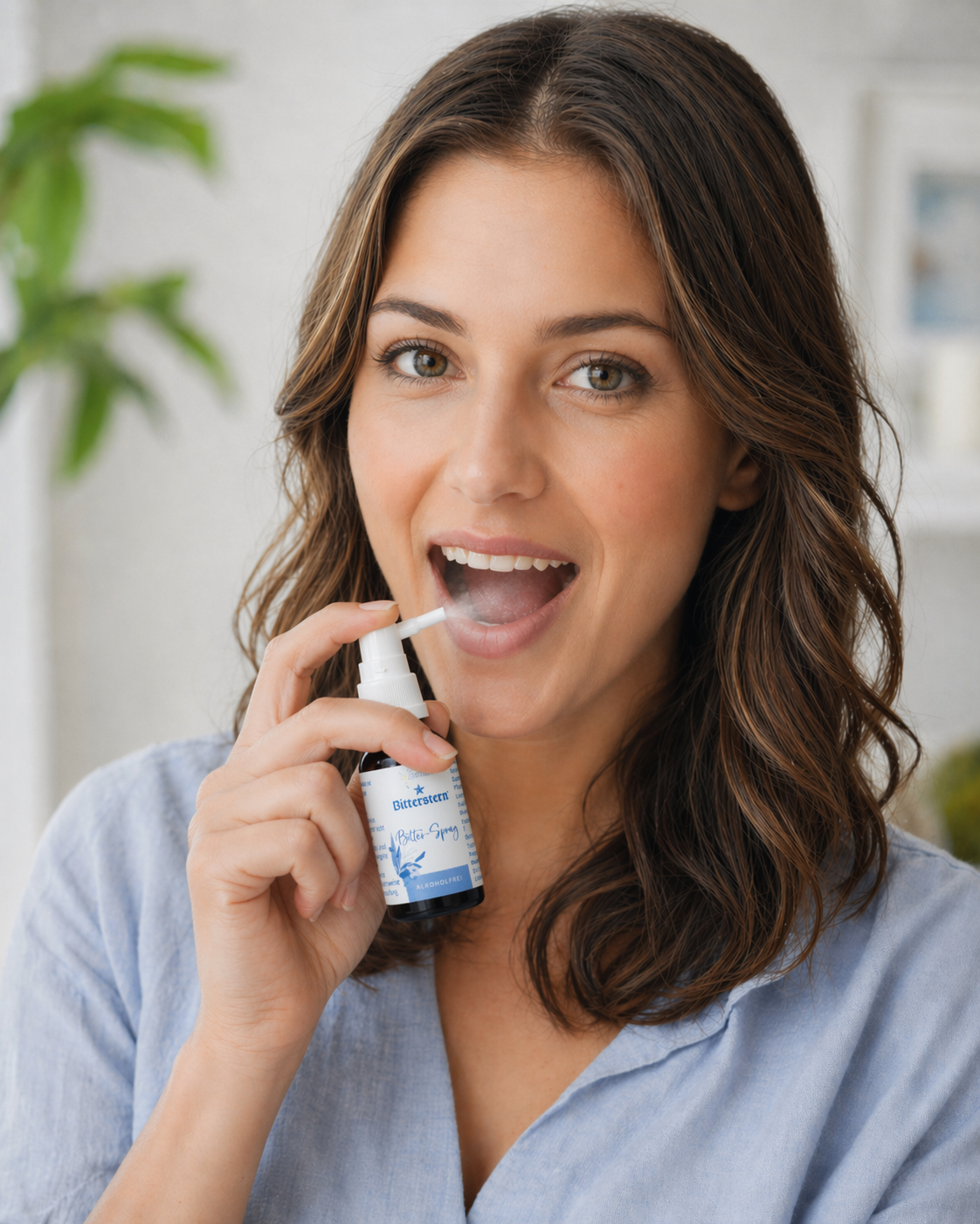 Frau sprüht Bitterspray in den geöffneten Mund und schaut in die Kamera