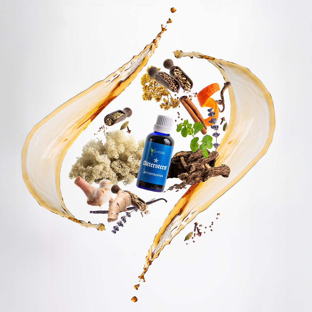 Ein helles Banner mit sanftem orange-beigen Farbverlauf links zu weiß rechts. Rechts im Bild schweben dynamisch eine dunkelblaue Flasche mit dem Etikett ‚Bitterstern Bittertropfen‘ sowie verschiedene Kräuter- und Wurzelextrakte (z. B. Stücke Ingwer- und Galgantwurzel, Lavendelblüten, getrocknete Schafgarbenkraut, Pomeranzenschalen) in einem geschwungenen Tropfen-Splash-Effekt. Der Eindruck vermittelt natürliche Kräuter-Inhaltsstoffe und Bewegtheit rund um das Produkt.
