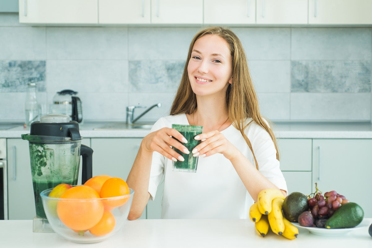 Frau trinkt einen Smoothie aus basischen Lebensmitteln