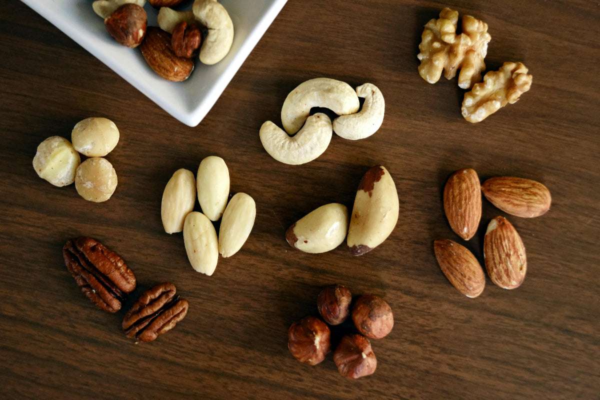 Mandeln, Haselnüsse, Walnüsse, Paranüsse und Cashews auf hölzerner Unterlage