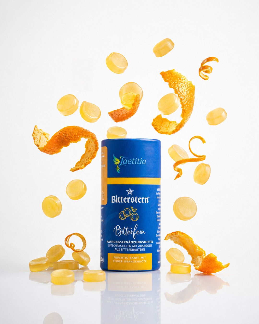 Dose Bitterstern Pastillen mit Stücken von Orangenschale und Pastillen, die um die Dose herumfliegen