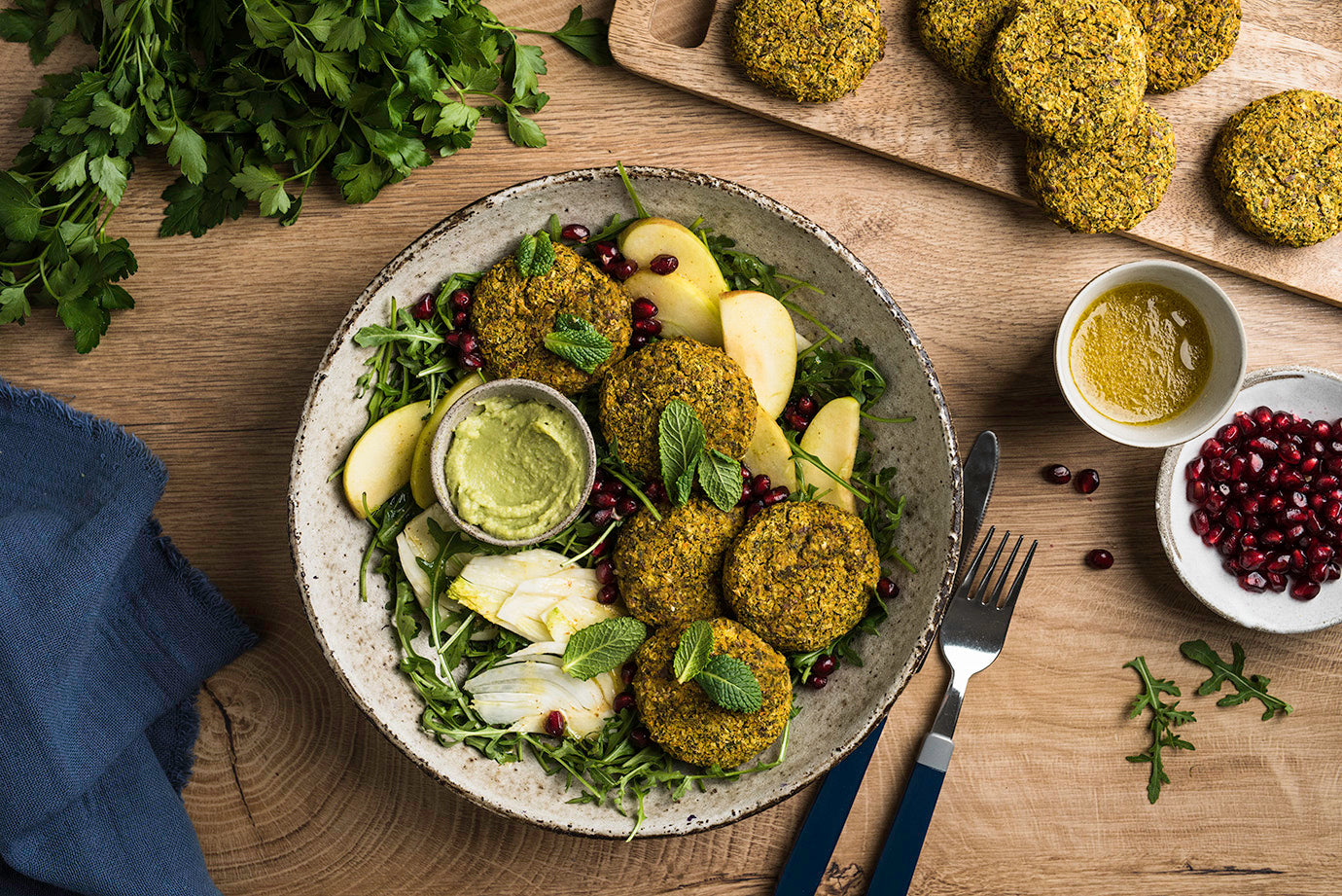 Bohnen-Kürbis-Grünkohl-Falafel mit Fenchel-Apfel Salat auf deinem Teller angerichtet mit Minzblättern garniert