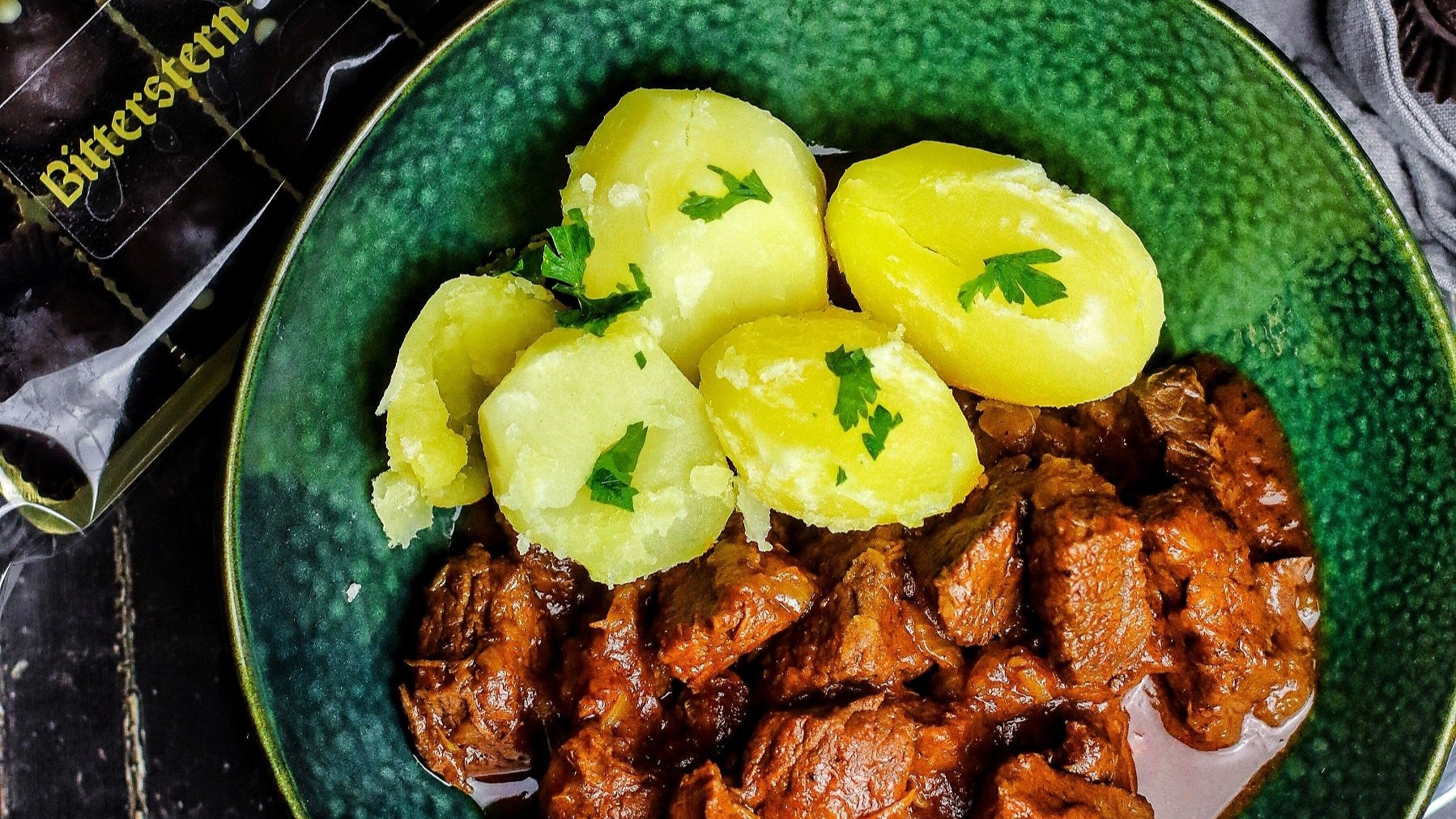 Rindergulasch mit Bitterstern Schokoladentrüffeln auf einem grünen Teller