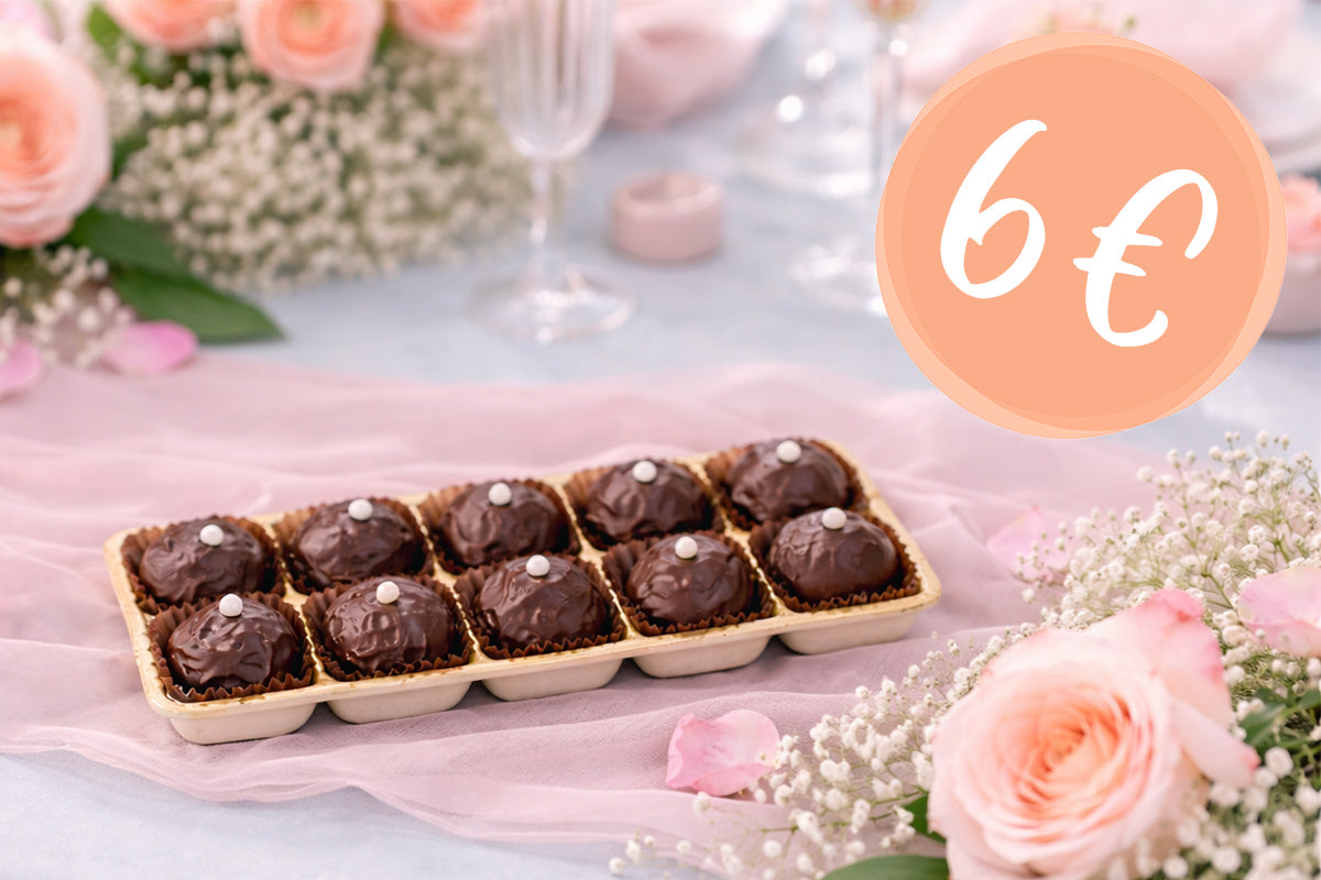 Ein 10-er Blister Bitterstern Schokoladentrüffel auf einem frühlingshaft gedeckten Tisch mit einer Bubble mit dem Hinweis auf eine Rabattaktion "6€"