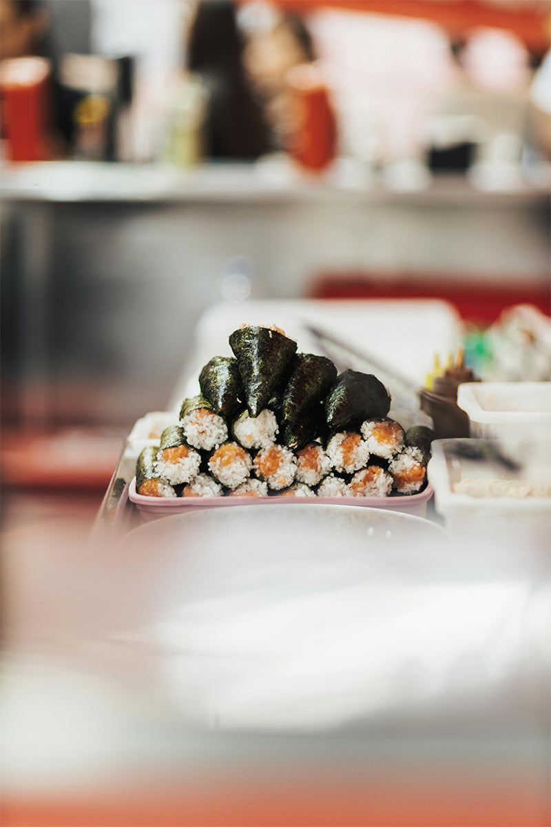 Ein paar Sushi-Rollen mit Reis, Lachs und Noriblättern gestapelt