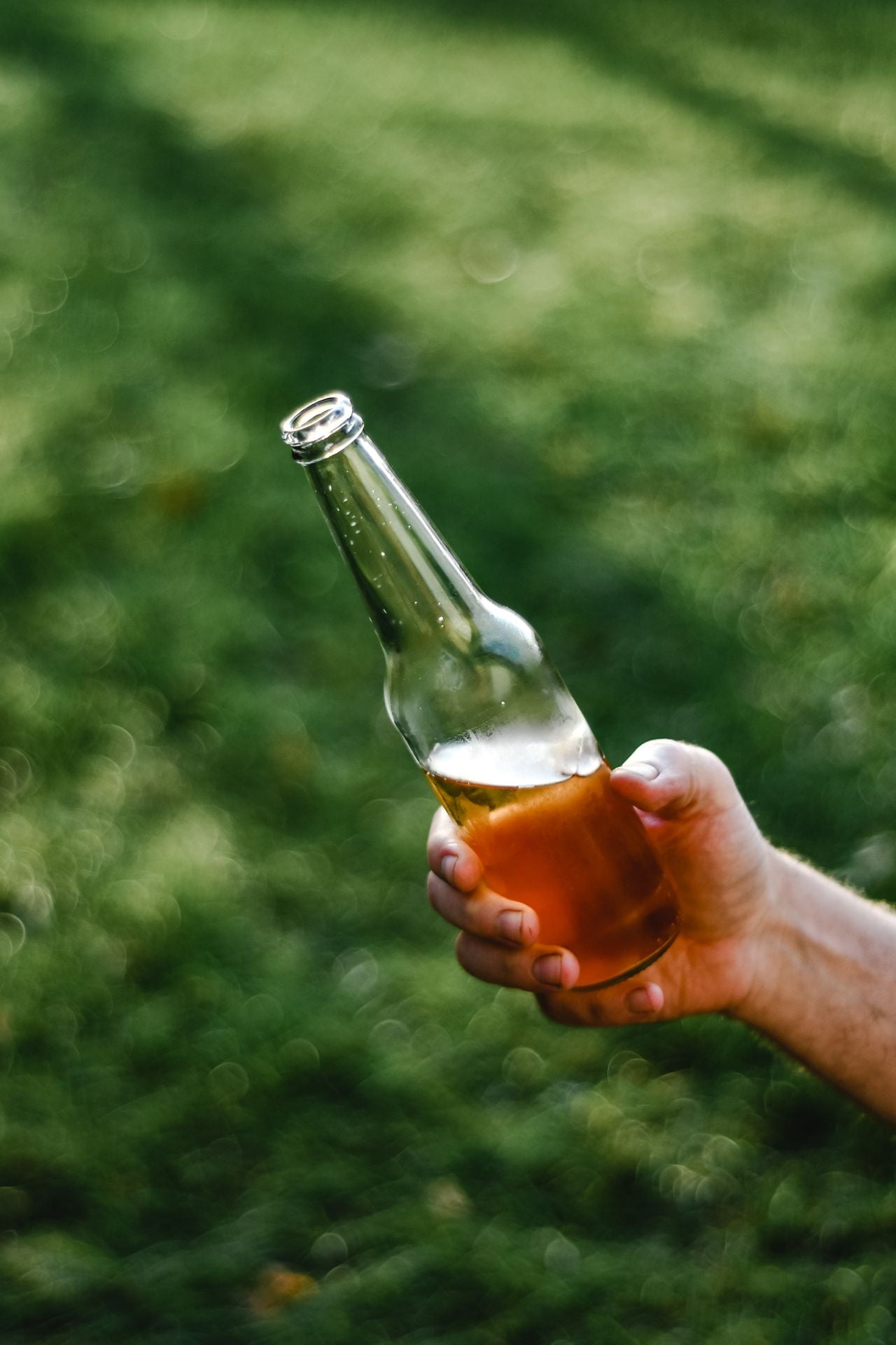 Hand hält eine Flasche alkoholfreies Bier – alkoholfreies Bier zählt zu den basisch verstoffwechselten Getränken.