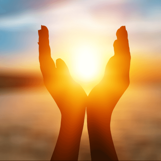 Hände einer Frau, die eine ausgeglichene Säure-Basen-Balance hat, umschließen die untergehende Sonne.