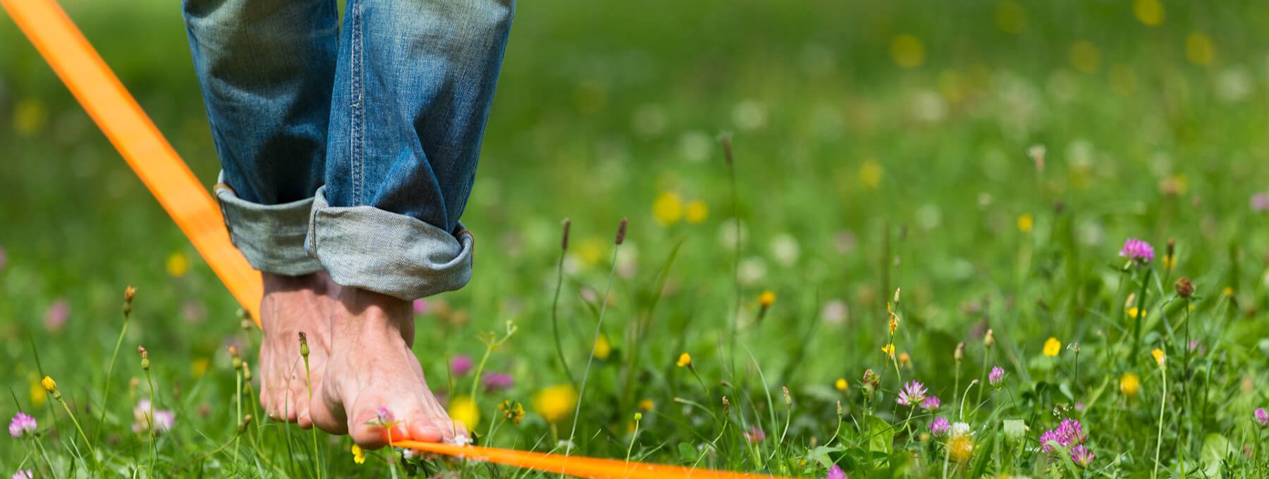Ein Mensch, der auf einer Slackline balanciert, als Symbol für ein ausbalanciertes Säure-Basen-Gleichgewicht. 
