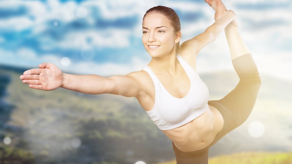 Junge Frau macht Sportübungen in der Natur und will damit ihren Stoffwechsel anregen