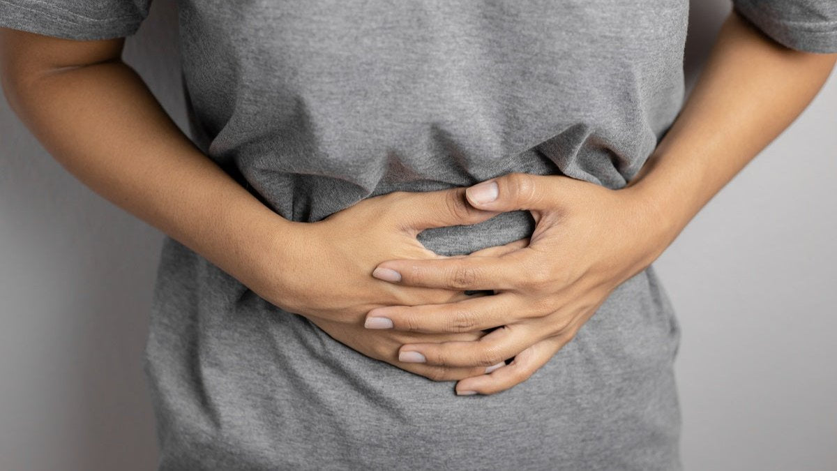 Frau leidet unter Völlegefühl und hält sich den Bauch