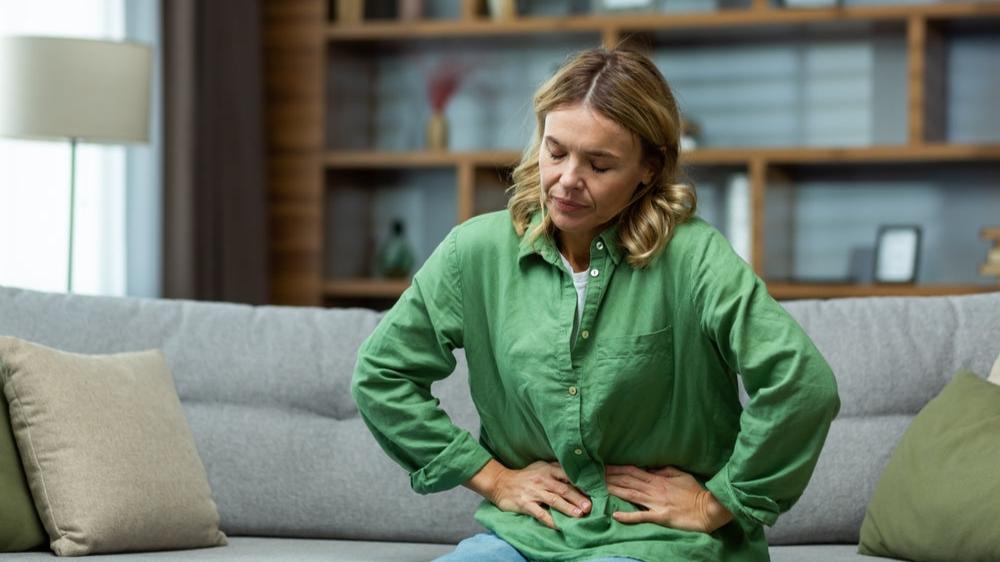 Frau sitzend Bauchschmerzen