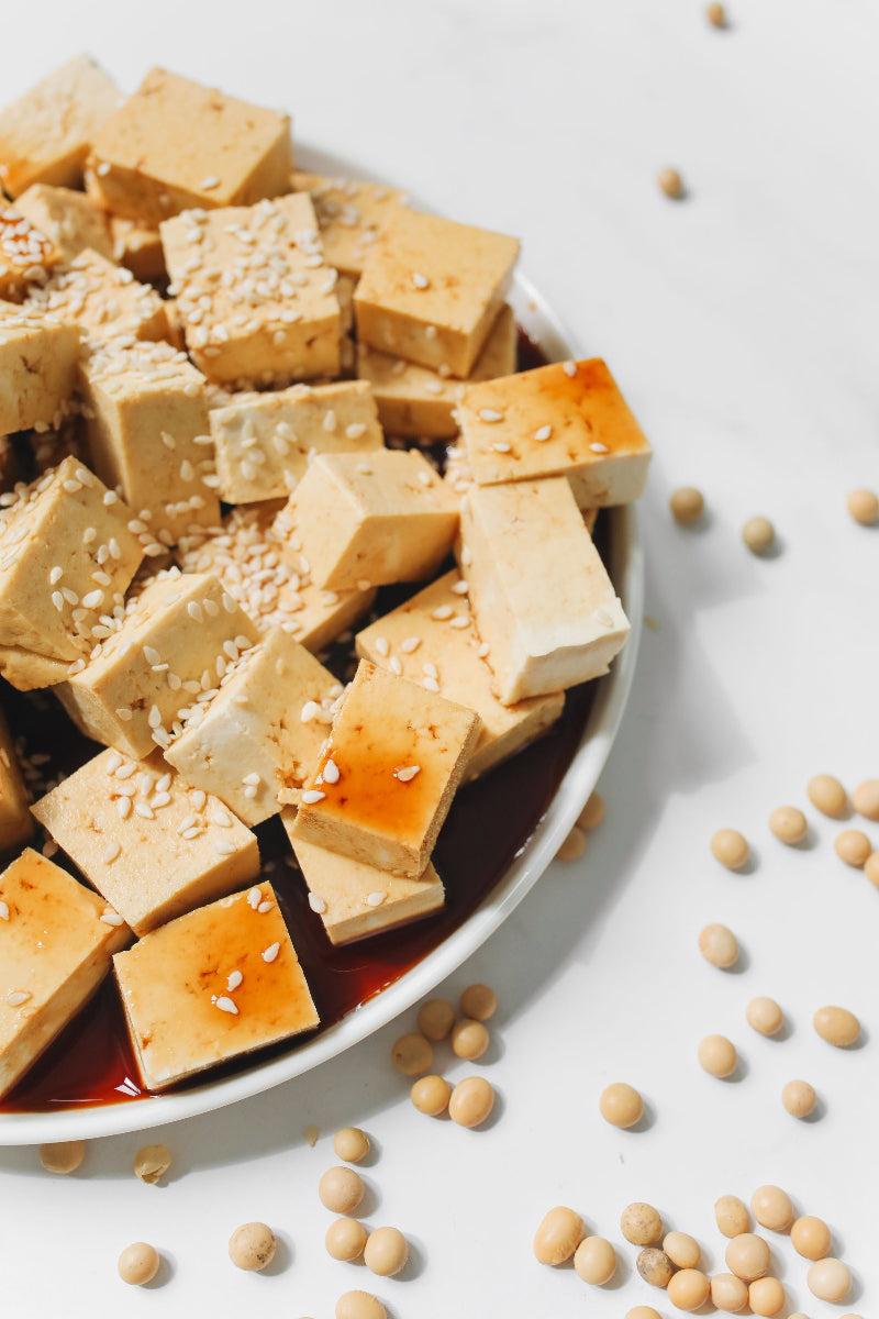Marinierte Tofuwürfel aus Soja mit Sesam auf einem Teller. Das Bild begleitet die Frage „Ist Soja basisch oder säurebildend?“ und die Einordnung von Tofu in der basischen Ernährung.